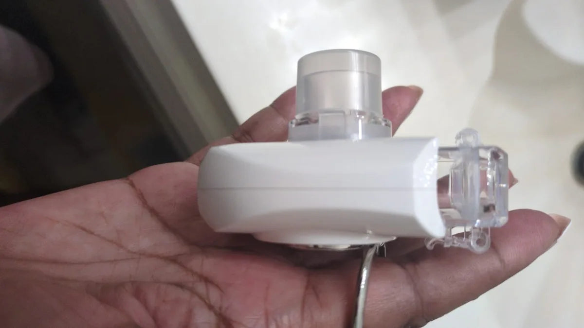 Small portable nebulizer resting in a hand