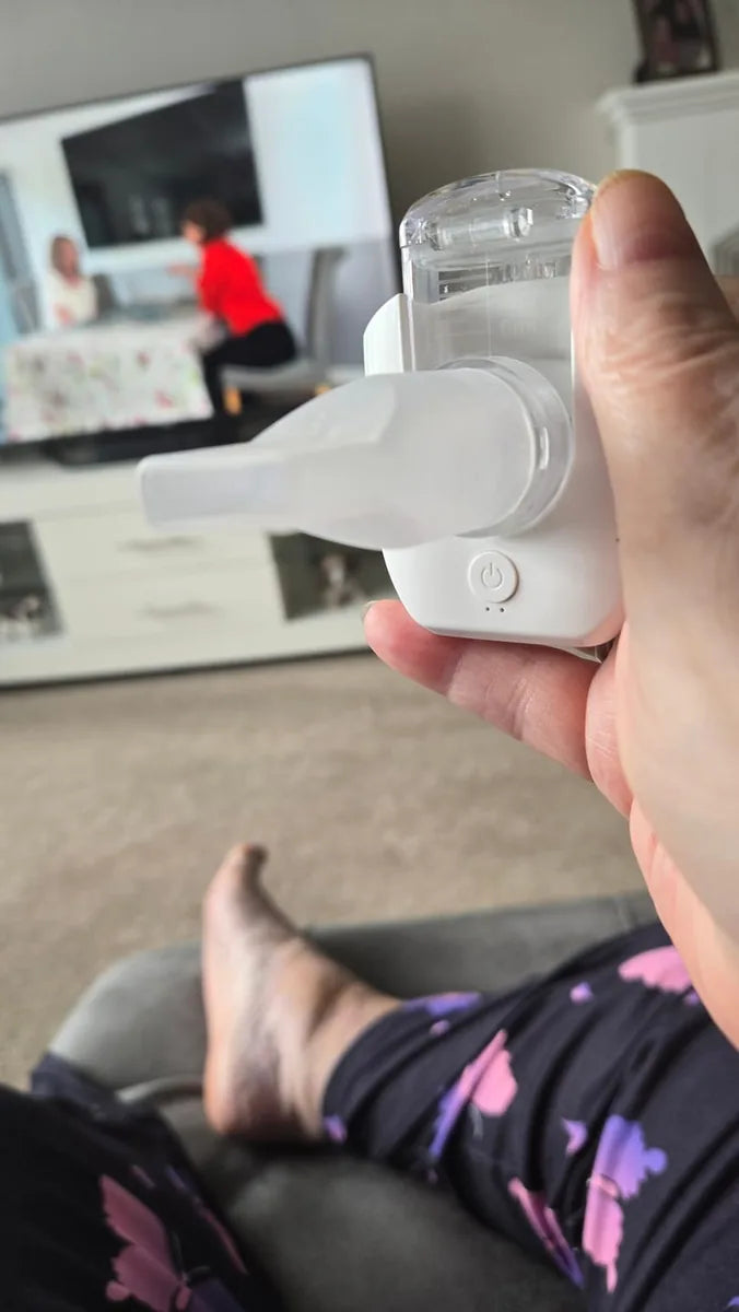A hand holding a portable nebulizer